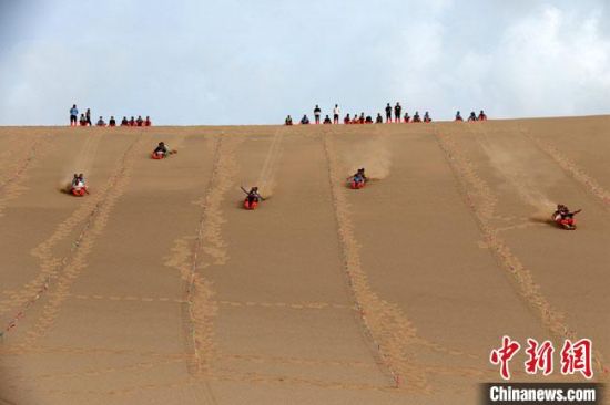 6月13日,敦煌鳴沙山月牙泉景區(qū)舉辦滑沙比賽。 張曉亮 攝 6月13日,敦煌鳴沙山月牙泉景區(qū)舉辦滑沙比賽。 張曉亮 攝