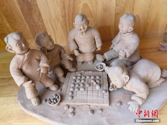 圖為泥塑作品展現(xiàn)下棋場景。 劉玉桃 攝 圖為泥塑作品展現(xiàn)下棋場景。 劉玉桃 攝