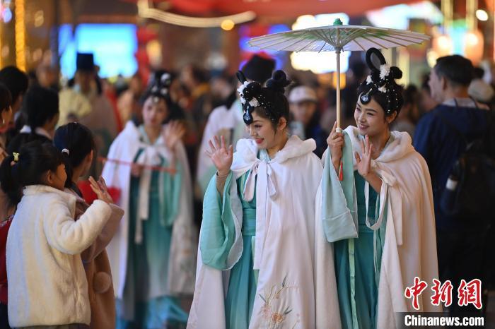 圖為街區(qū)人員著傳統(tǒng)服飾與游人互動(dòng)。李亞龍 攝</p><p>